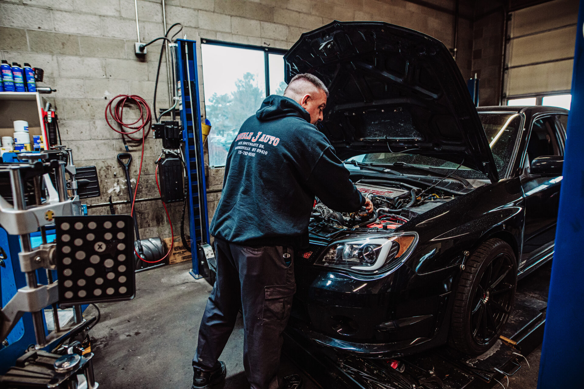 List of services as a man repairs a car in the background